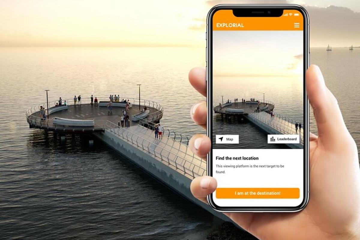 a person holding a cell phone in front of a pier