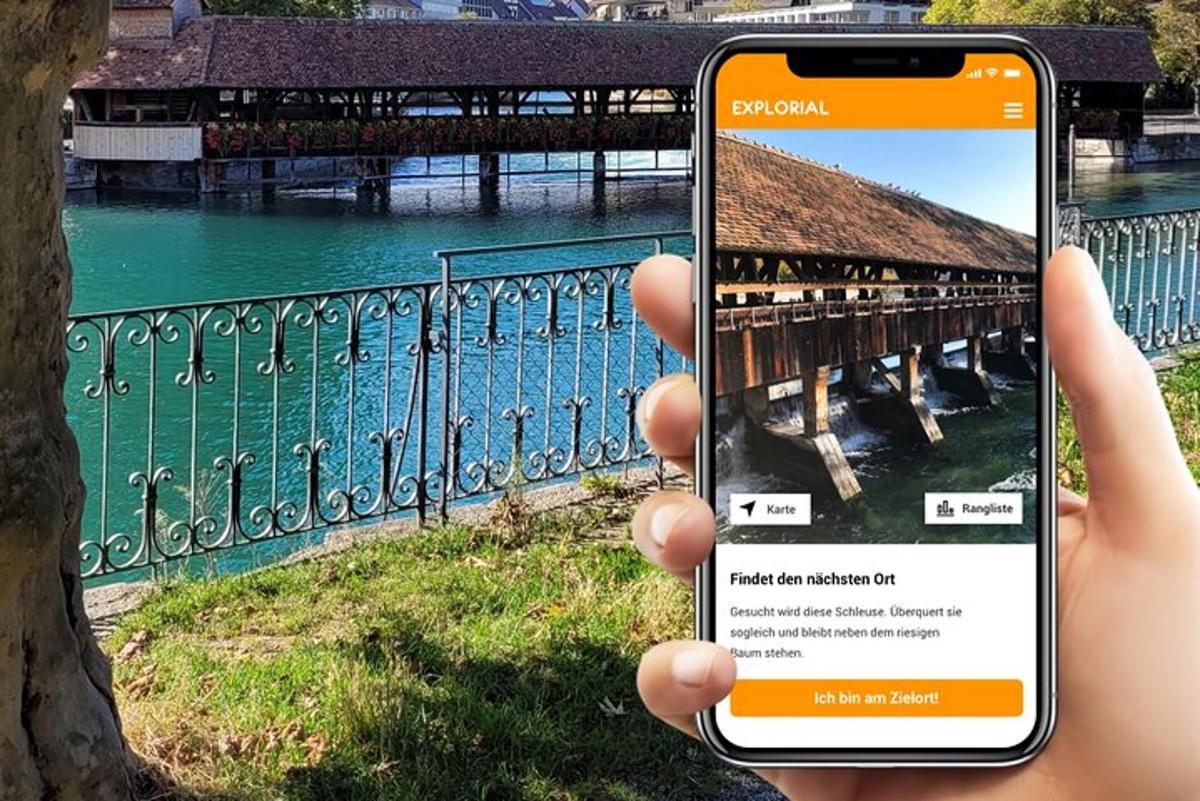a person holding up a cell phone to take a picture of a bridge