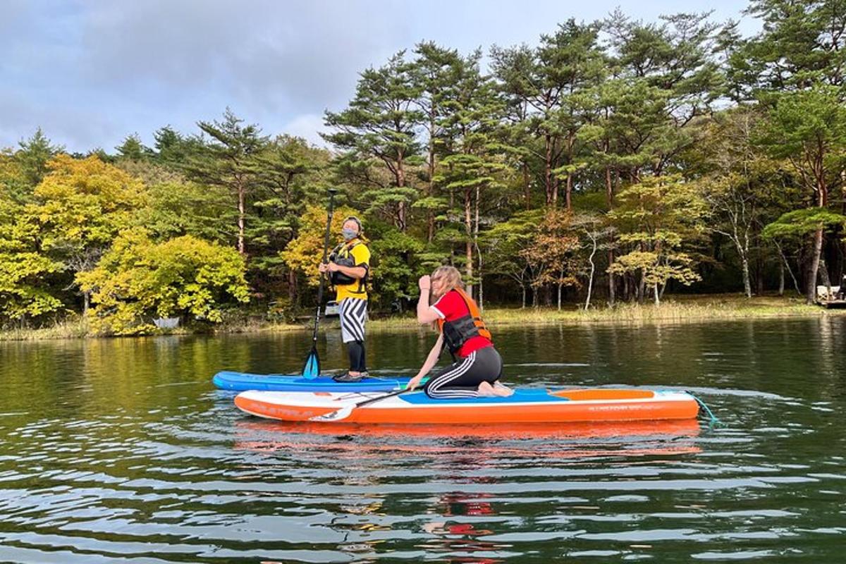 a man and a woman on a paddle board on the water