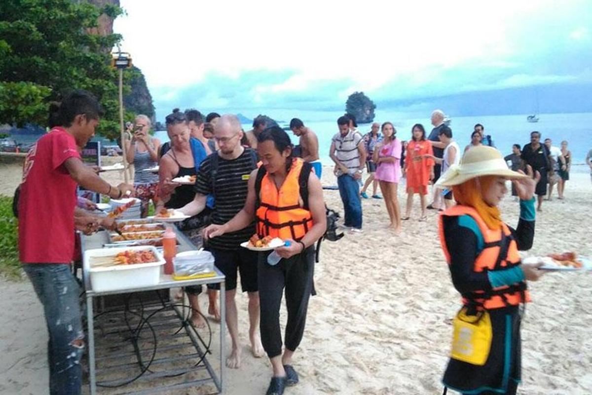 un grupo de personas comiendo comida en la playa