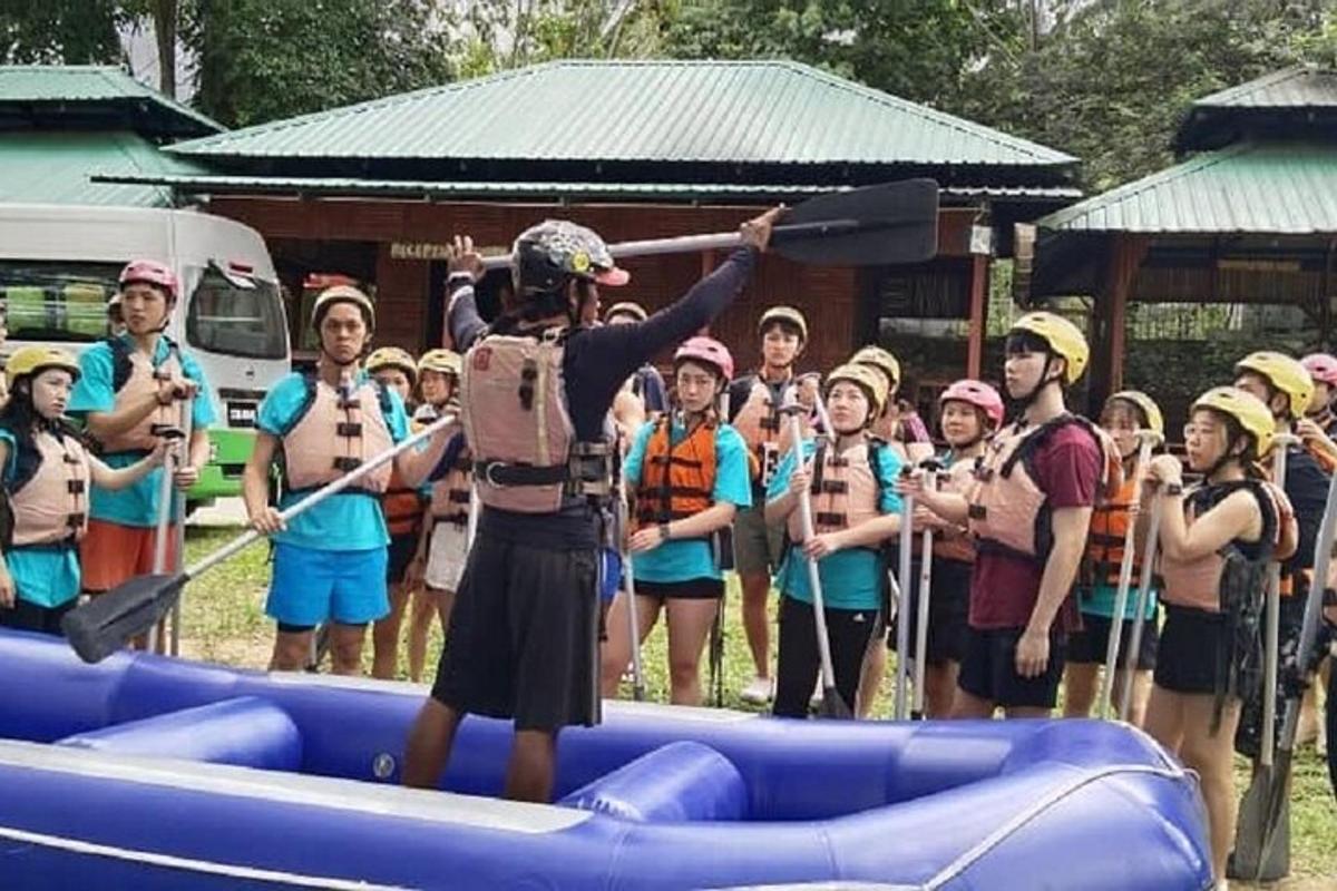 a group of people standing on a raft with paddles