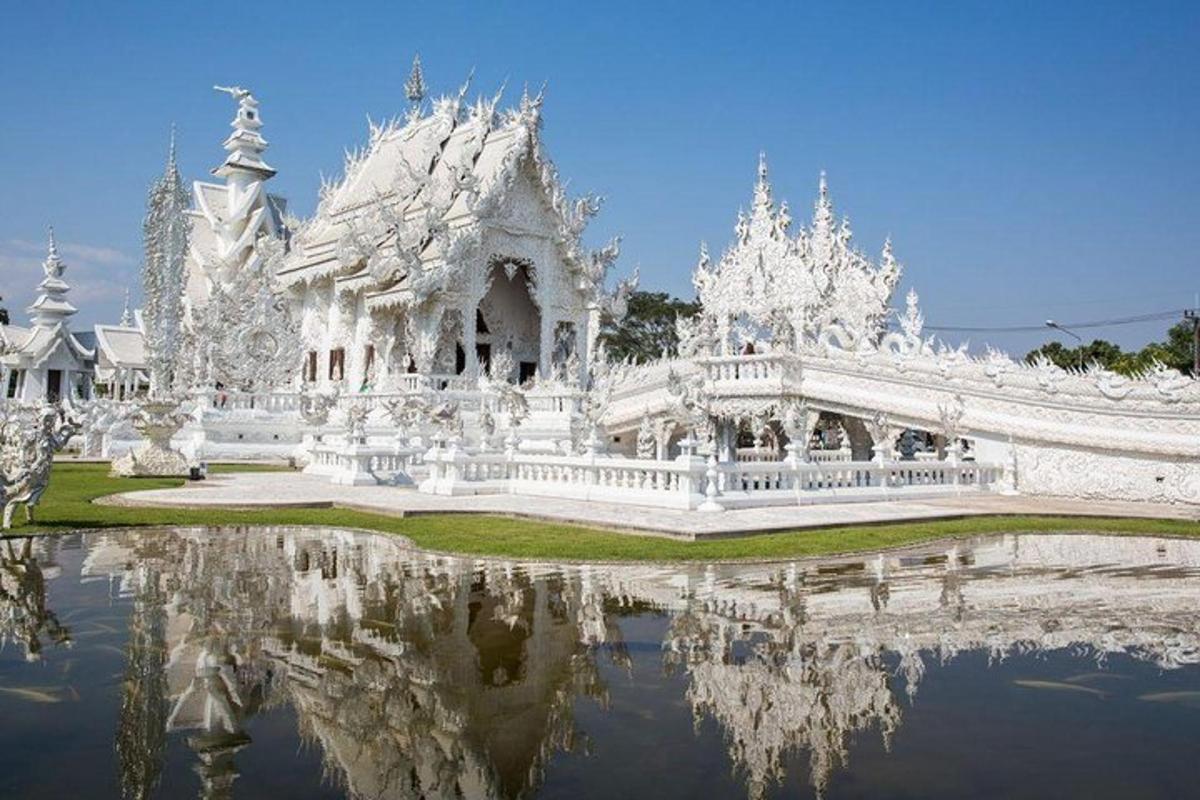 a white building with its reflection in the water