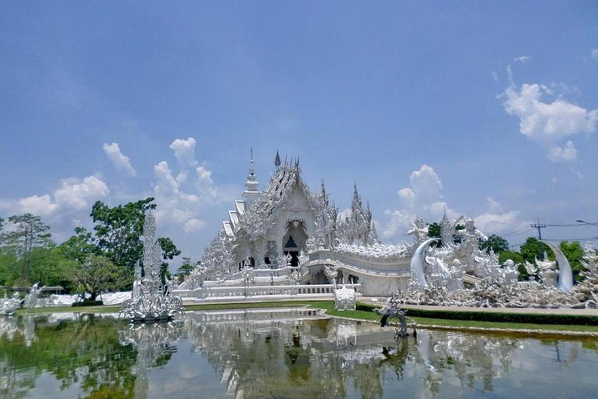 một tòa nhà màu trắng có một cái ao ở phía trước