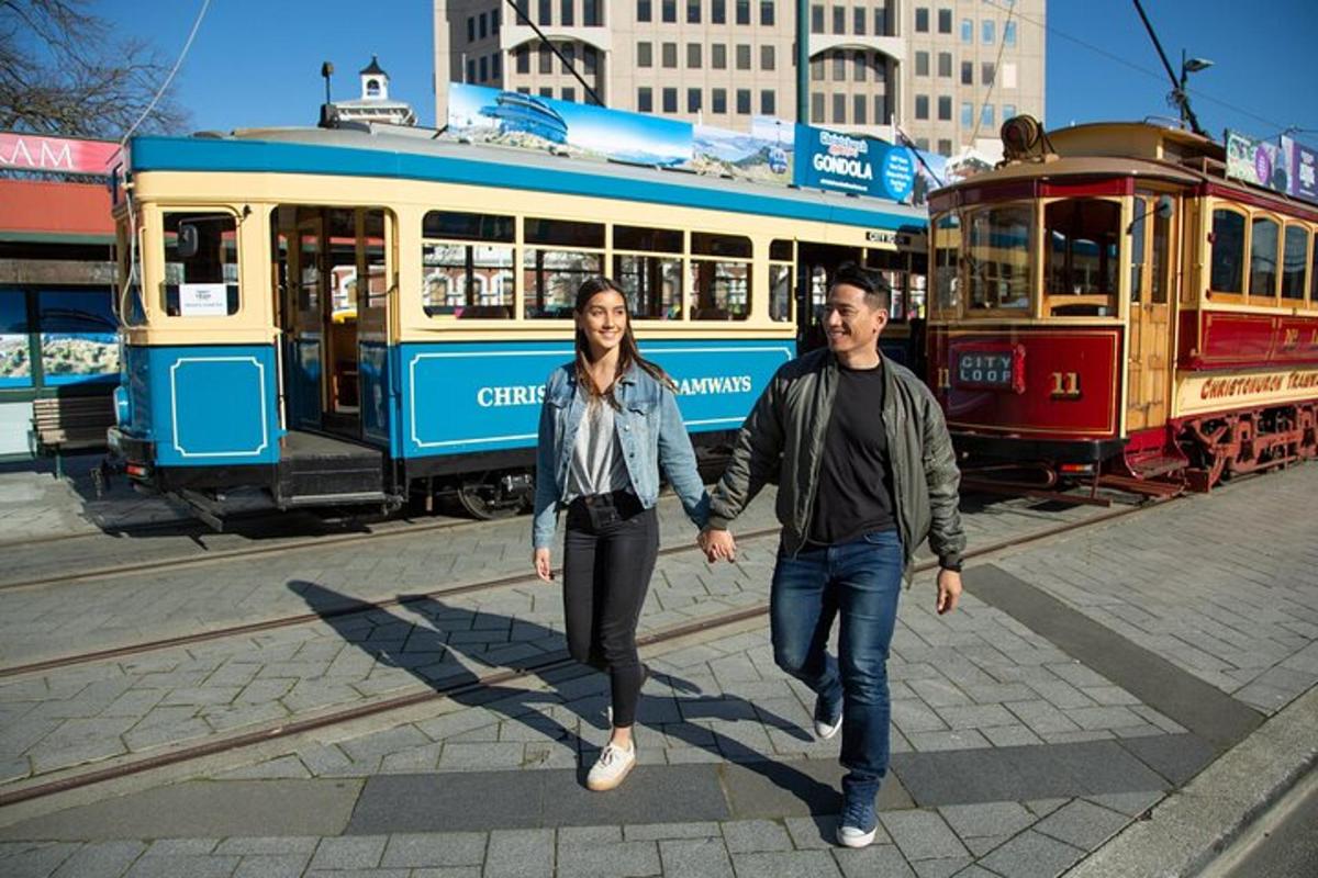 a man and woman walking in front of a tram