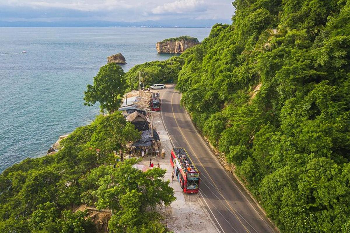 a bus driving down a road next to the ocean