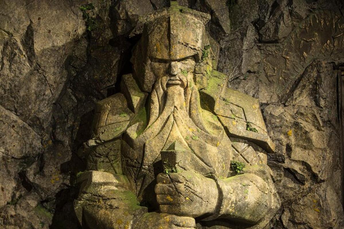 a statue of a man sitting in a stone wall