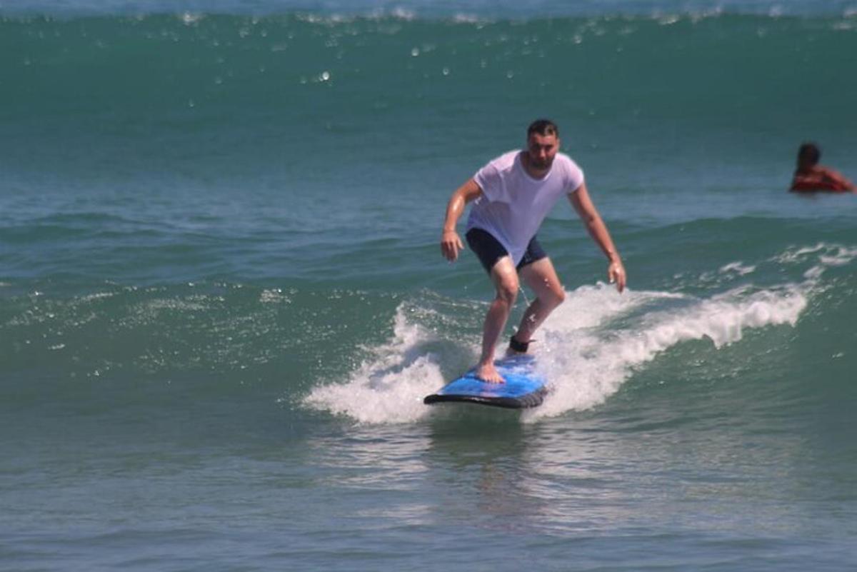 um homem pegando uma onda em uma prancha de surfe no oceano