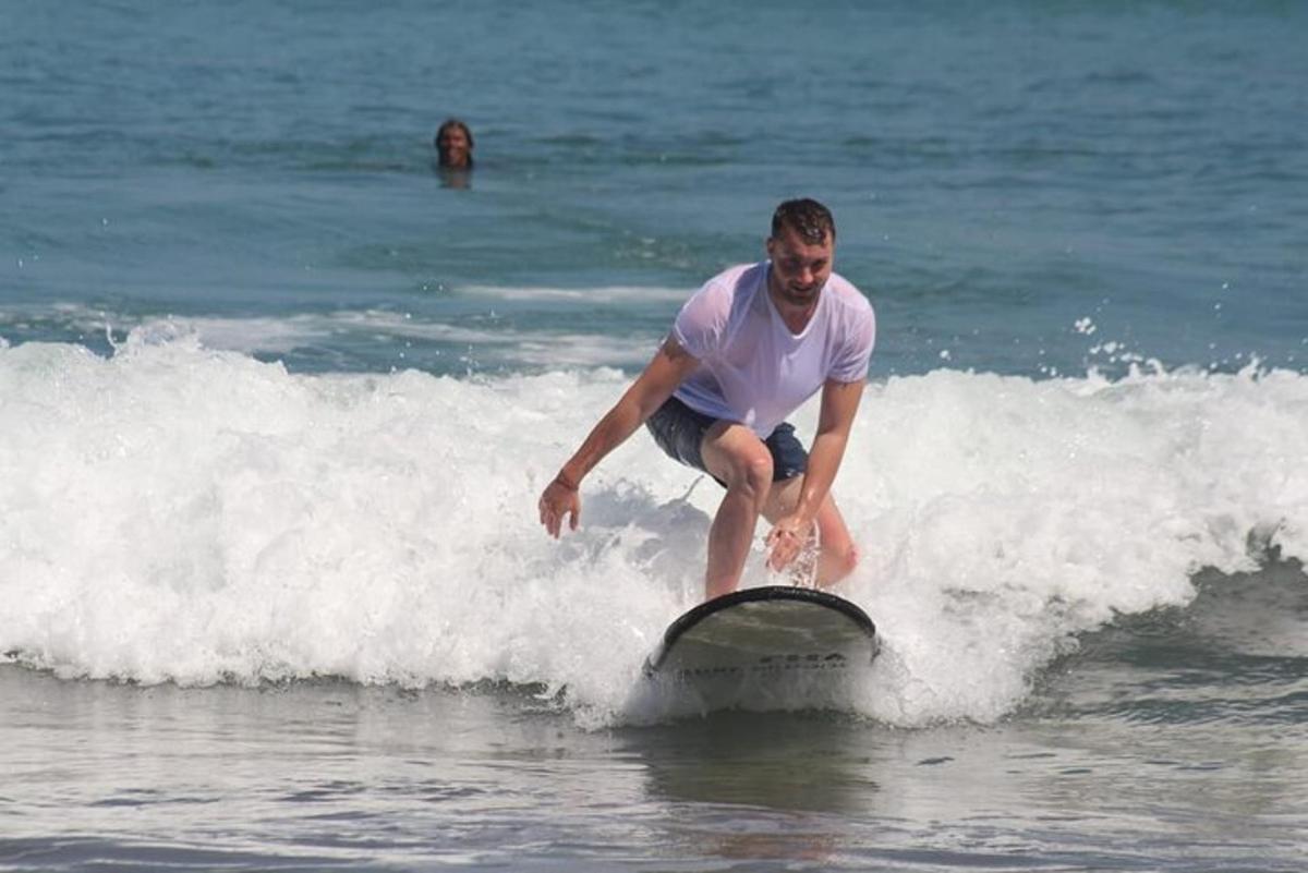 um homem pegando uma onda em uma prancha de surfe no oceano