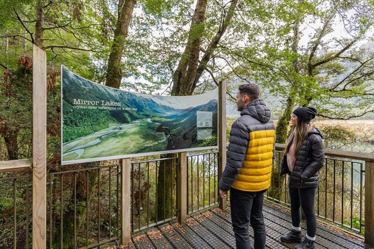 two people standing on a bridge with a sign