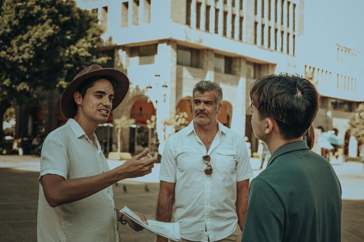 dva muži stojící vedle muže dívajícího se na mobilní telefon
