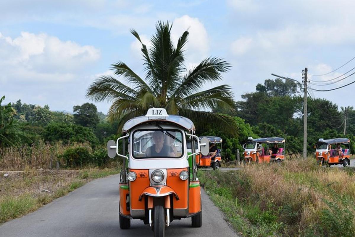 an orange and white truck driving down a road