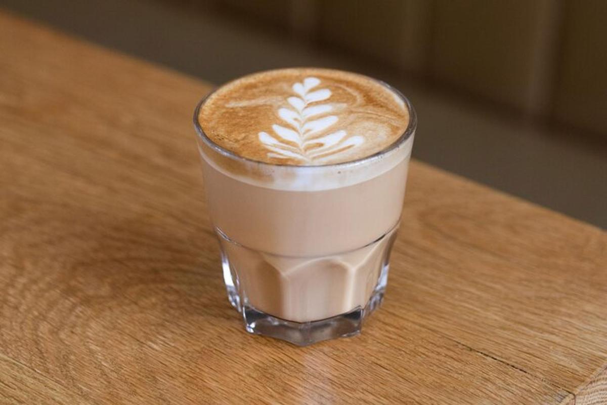 un pahar de cafea așezat pe o masă de lemn