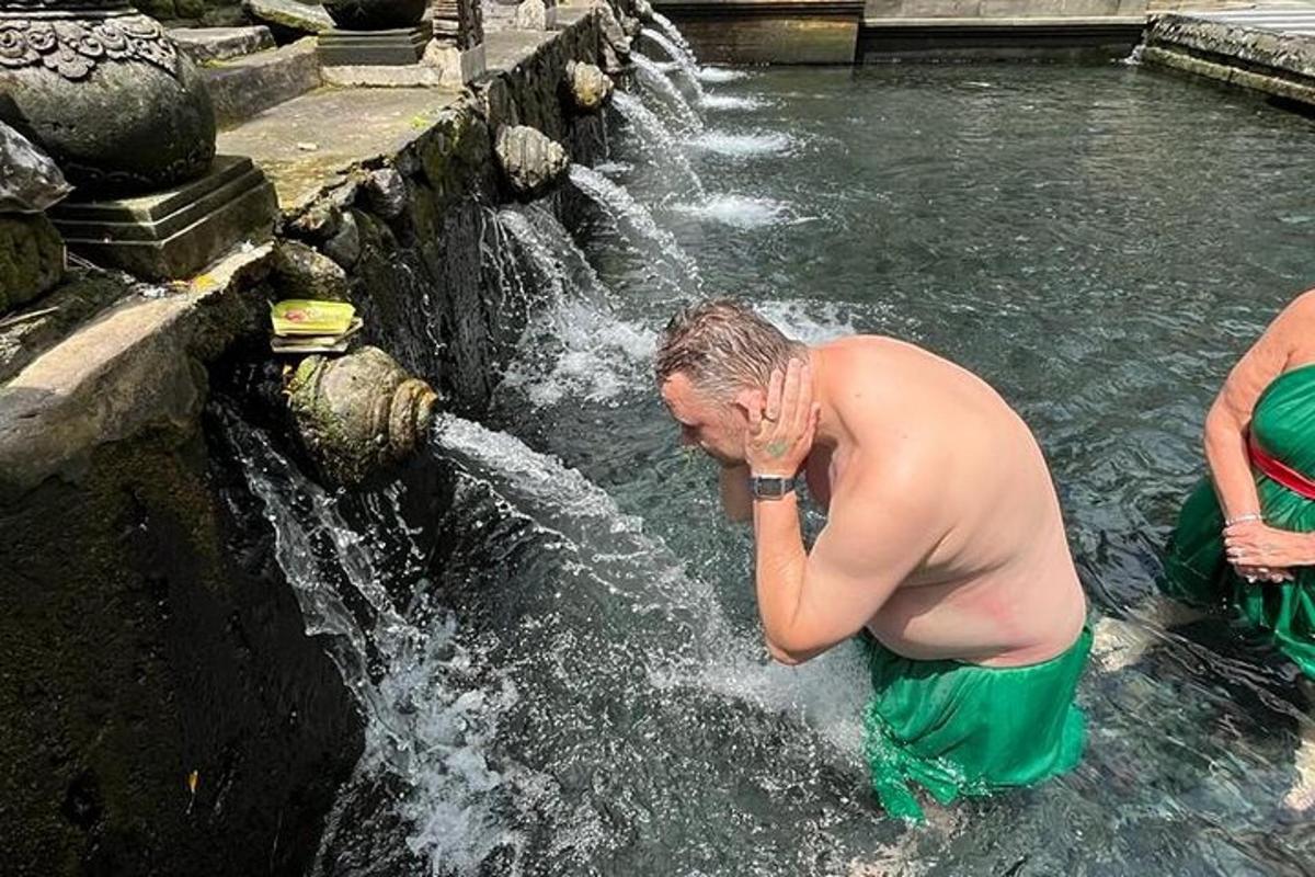 muž stojící před vodopádem