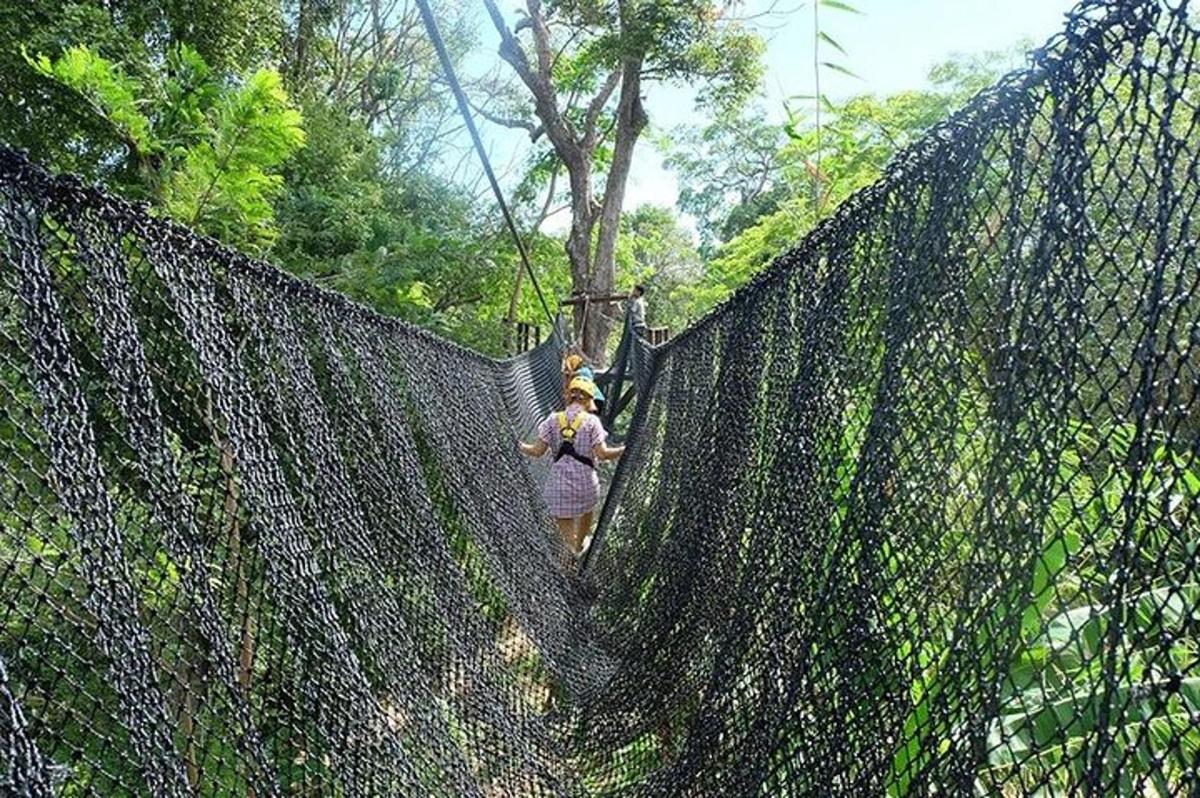 Una mujer caminando a través de una valla en la jungla.