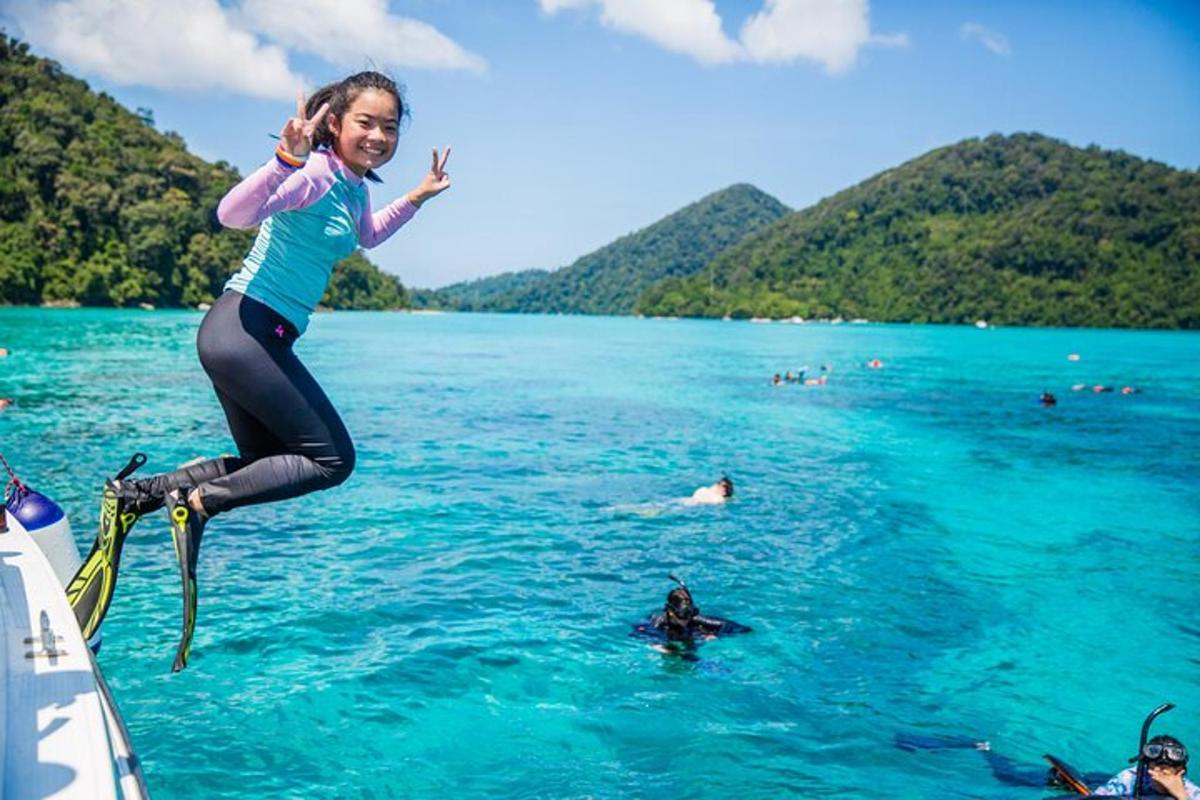 a woman jumping off of a boat in the water