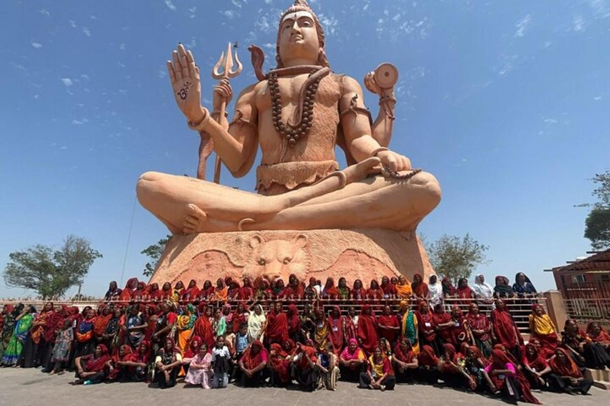 un gruppo di persone in piedi davanti a una grande statua