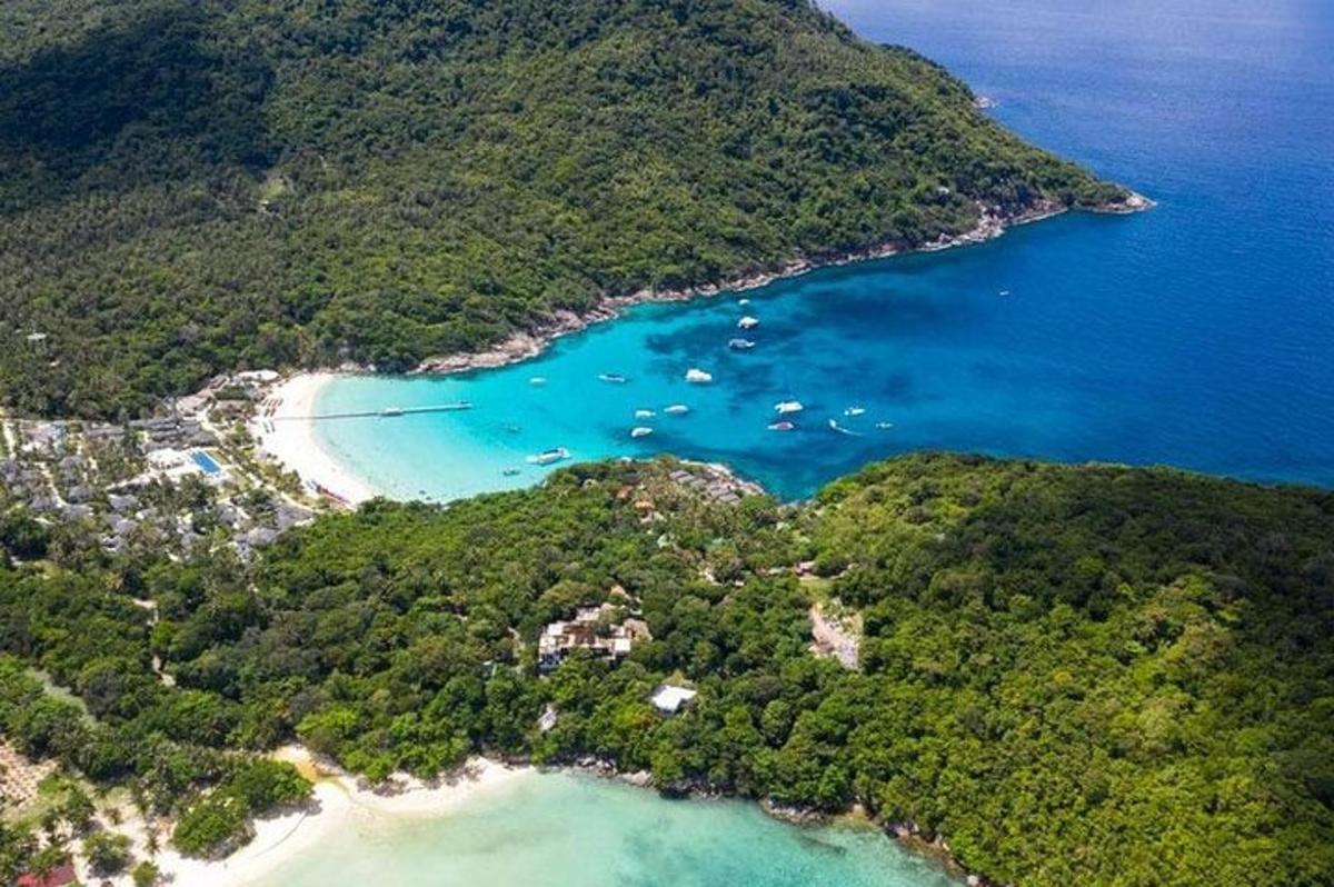 an aerial view of a beach with boats in the water