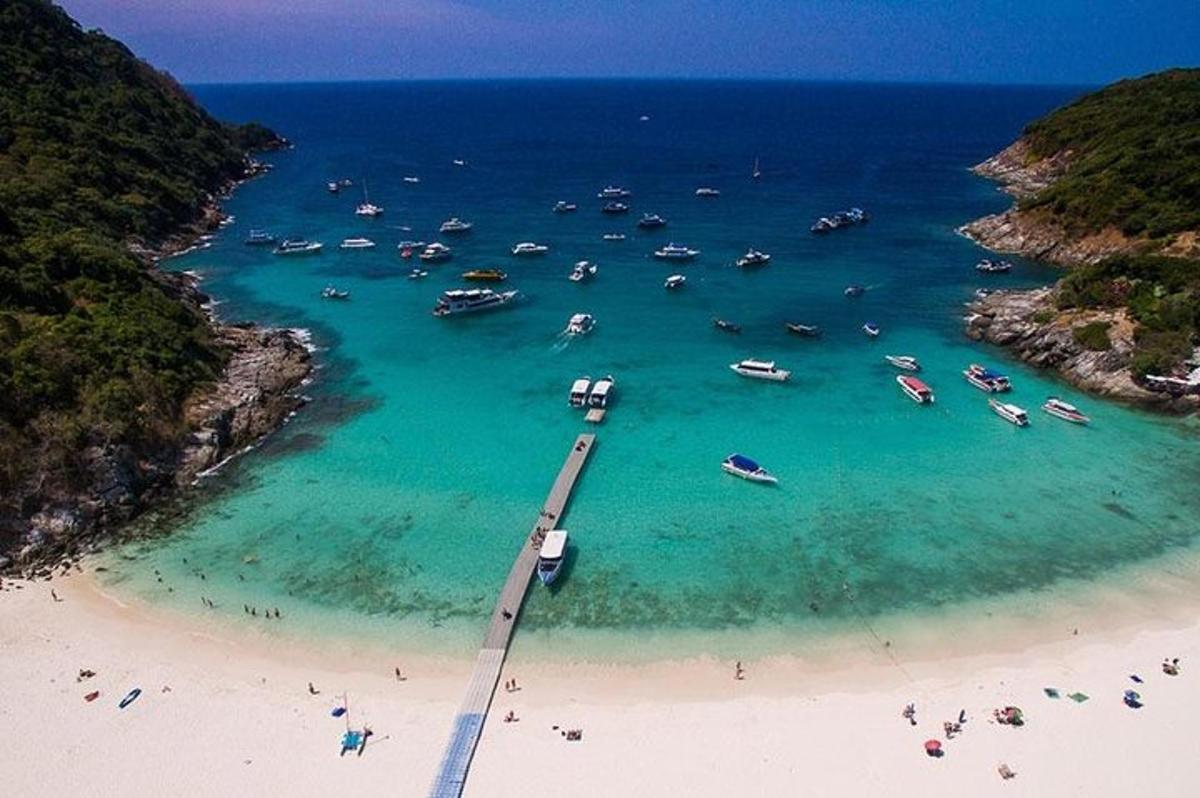a bridge over a beach with boats in the water