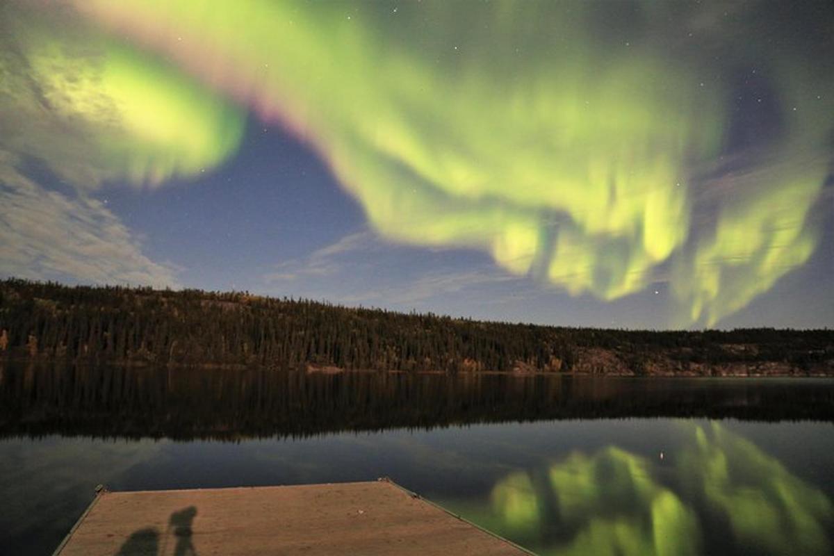 a person standing on a dock near a lake