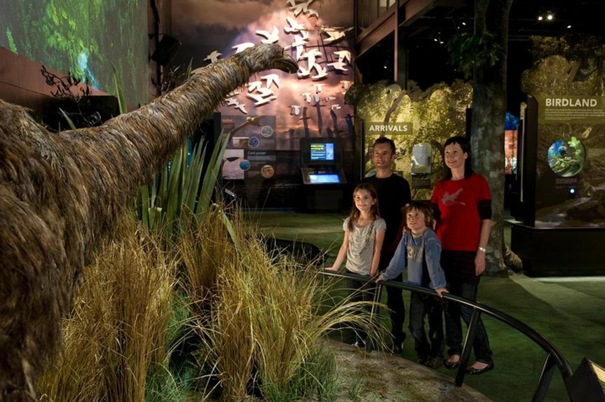 a family standing in front of a dinosaur exhibit
