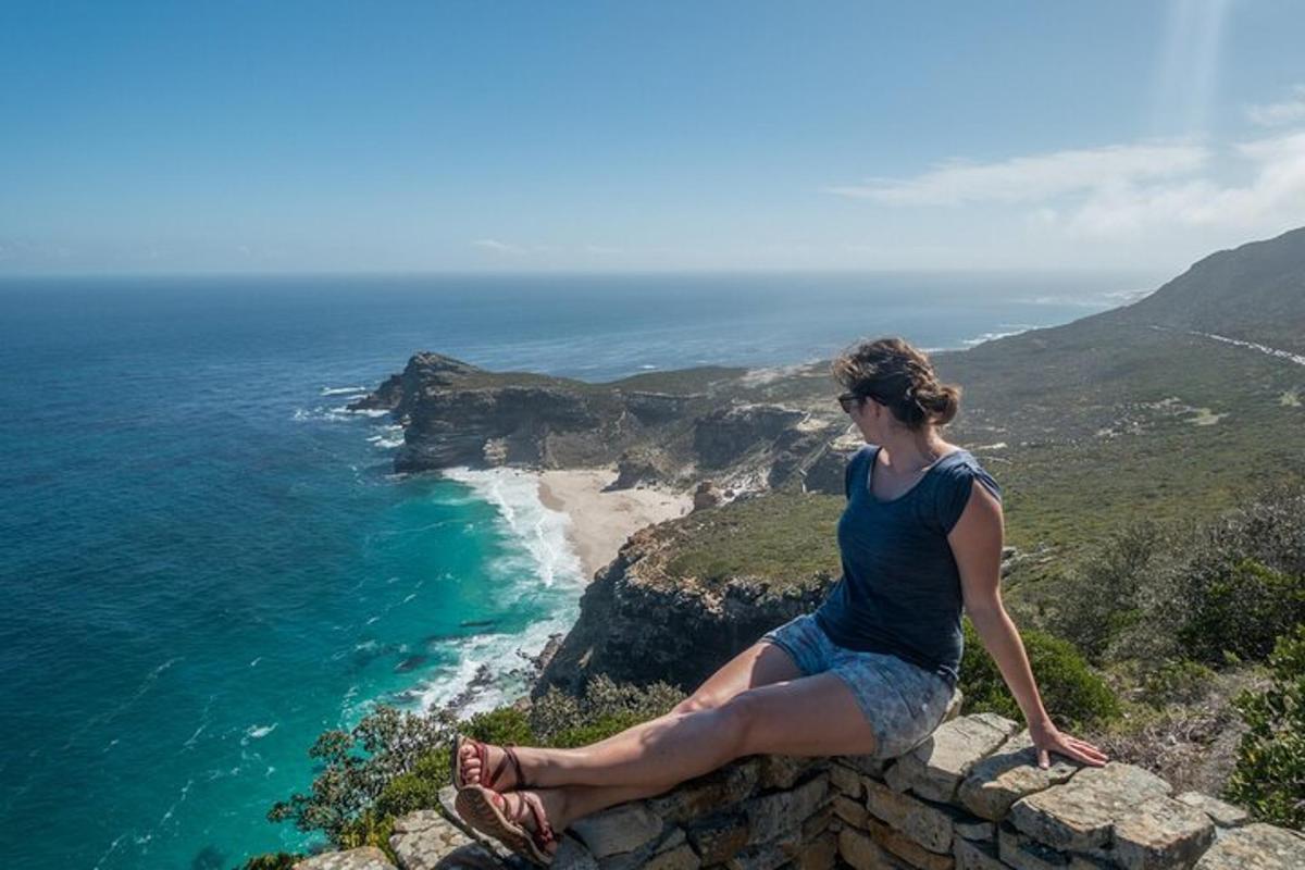 een vrouw zittend op een rots met uitzicht op de oceaan
