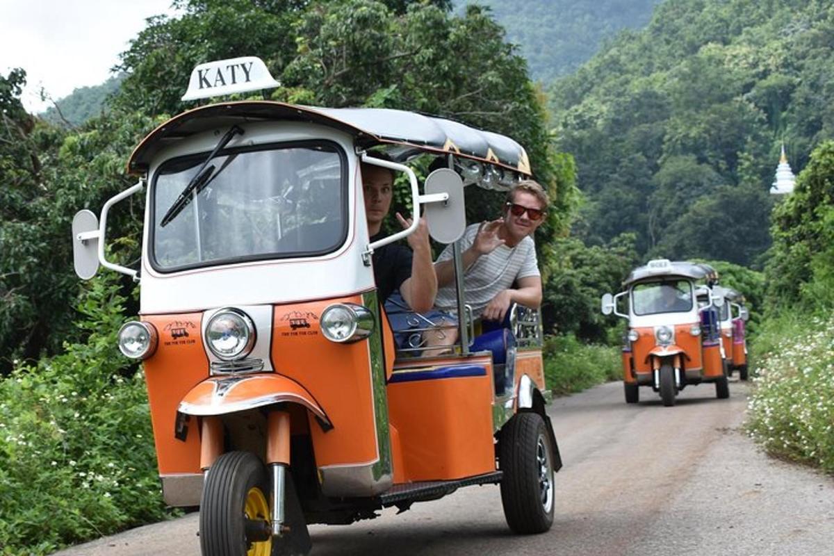 Un grupo de personas viajando en un vehículo naranja y blanco.