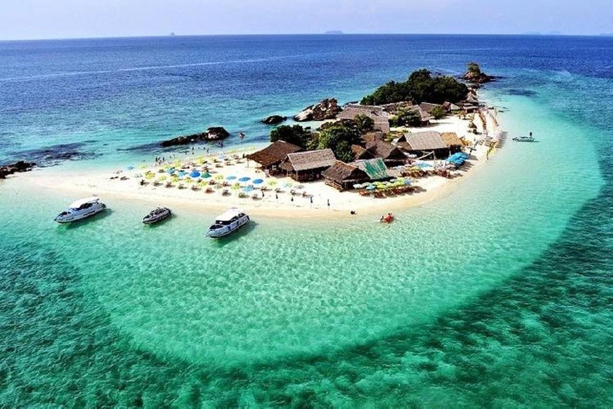 otok v oceanu s čolni v vodi