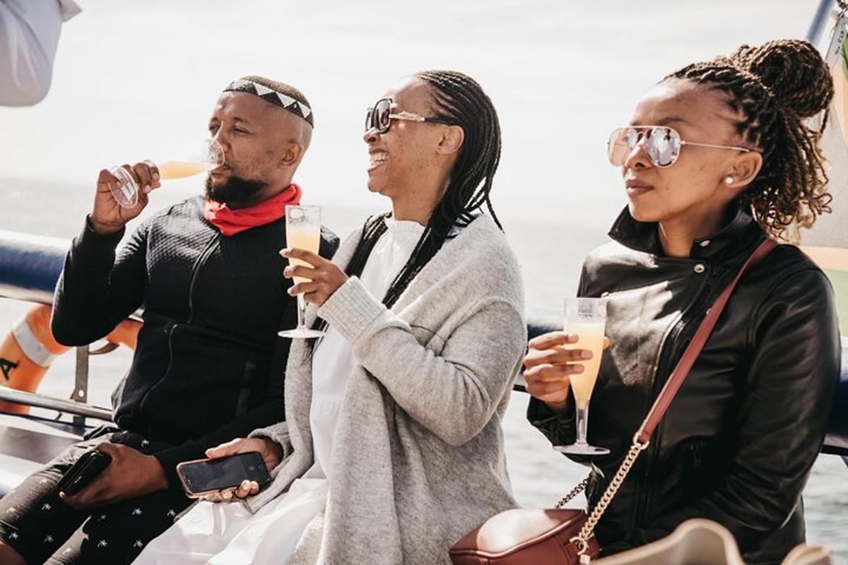 a group of three people sitting on a boat drinking champagne