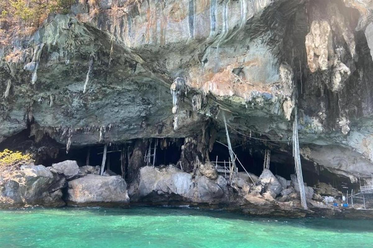 una grotta con acqua che gocciola dal lato di una scogliera
