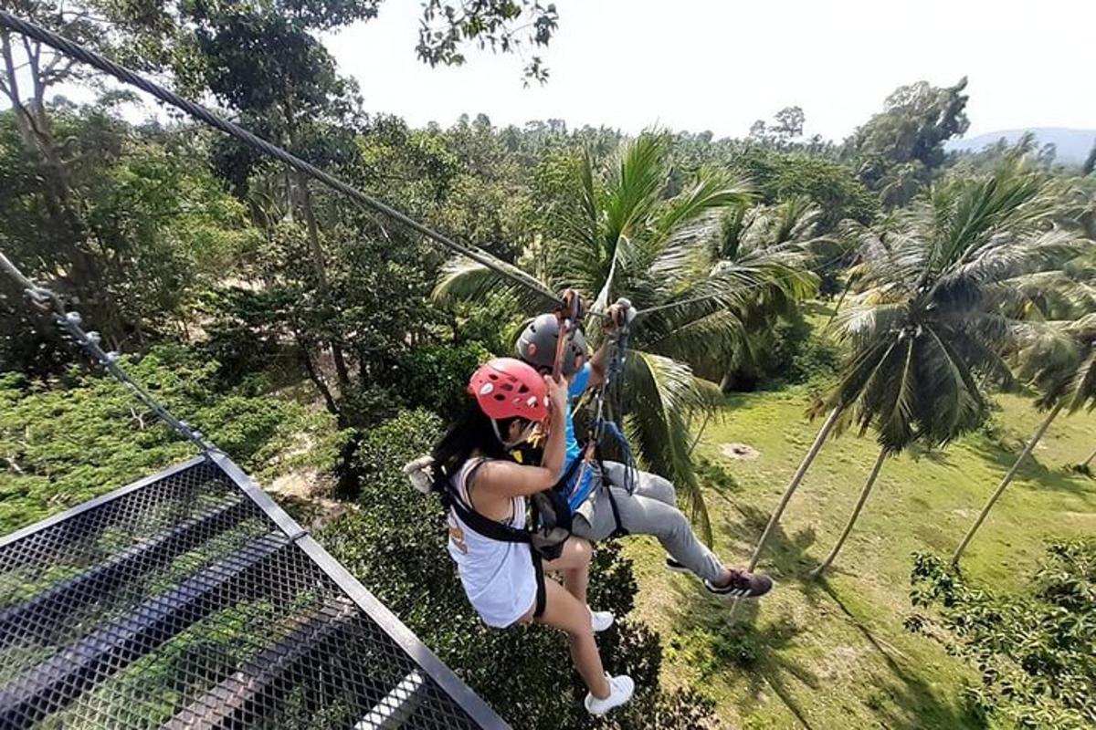 duas pessoas em uma tirolesa na selva