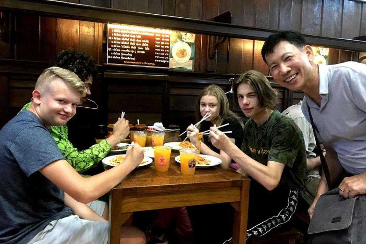Un grupo de personas sentadas en una mesa comiendo comida