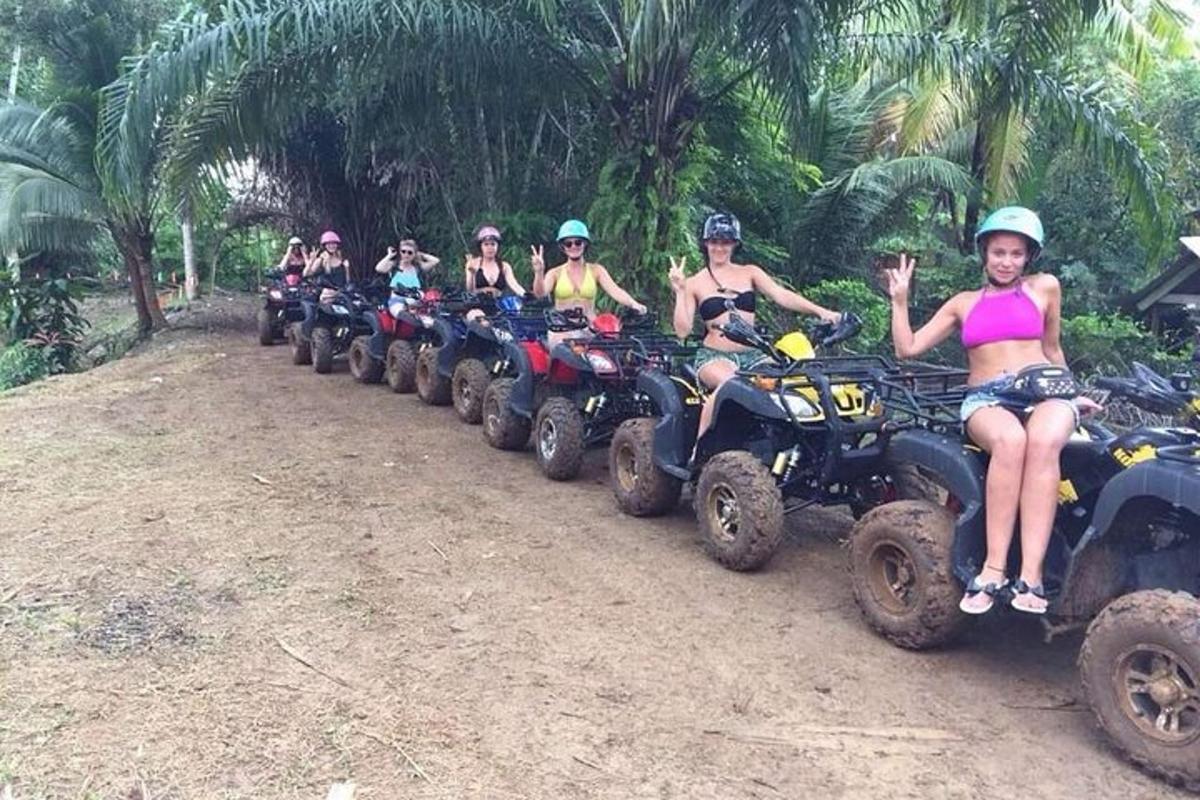 um grupo de pessoas andando de quadriciclo em uma estrada de terra
