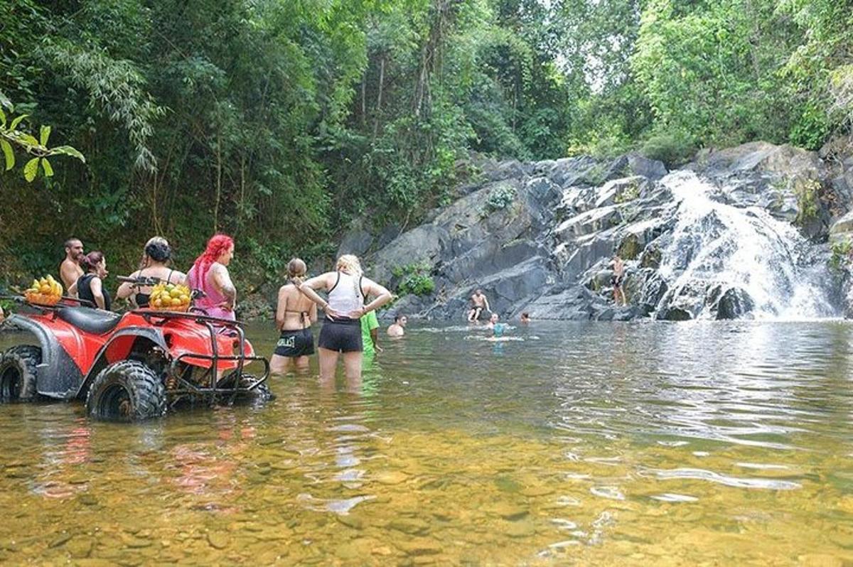 un gruppo di persone in piedi in un fiume con un quad in acqua