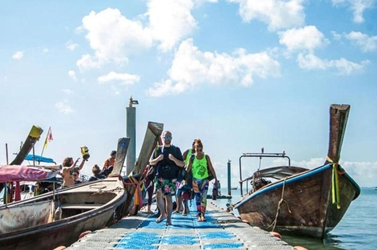 cilvēku grupa, kas pastaigājas pa piestātni