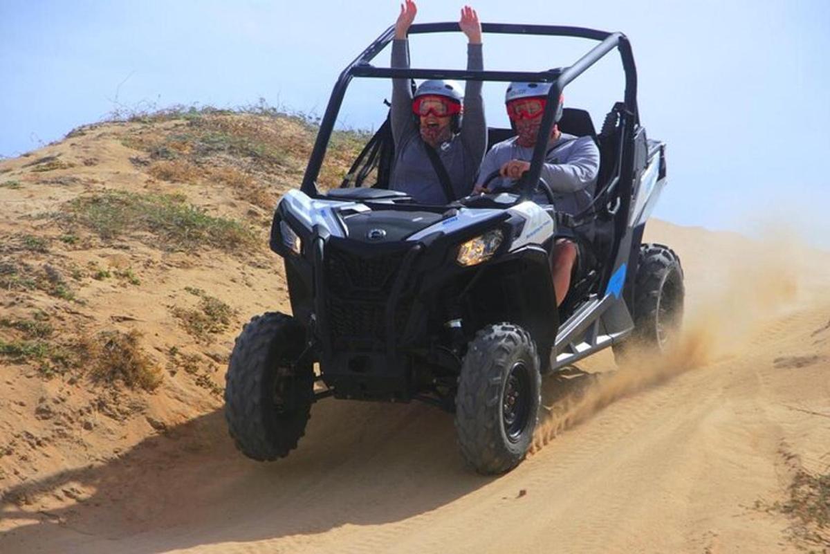 to mænd kører i en jeep på en grusvej