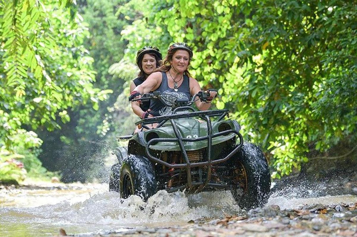 duas pessoas andando em um quadriciclo na água