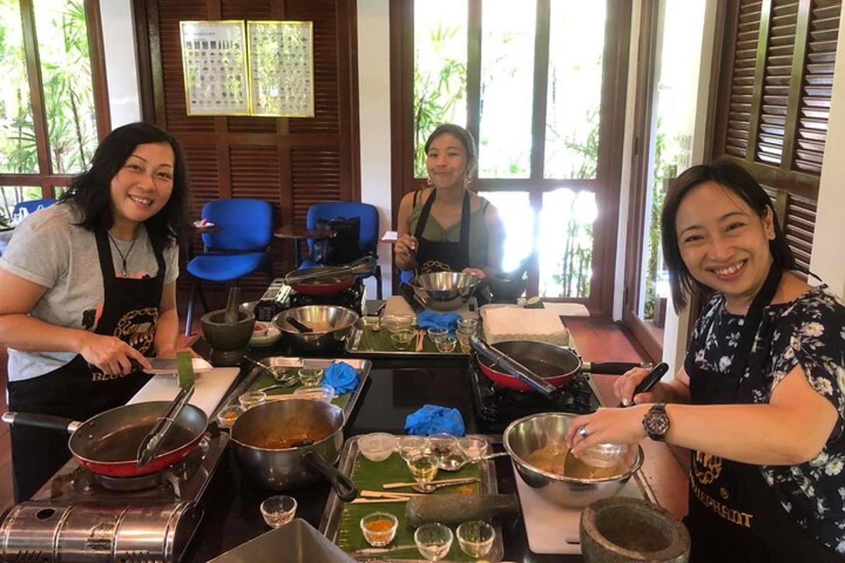 sekumpulan wanita berdiri mengelilingi meja menyediakan makanan