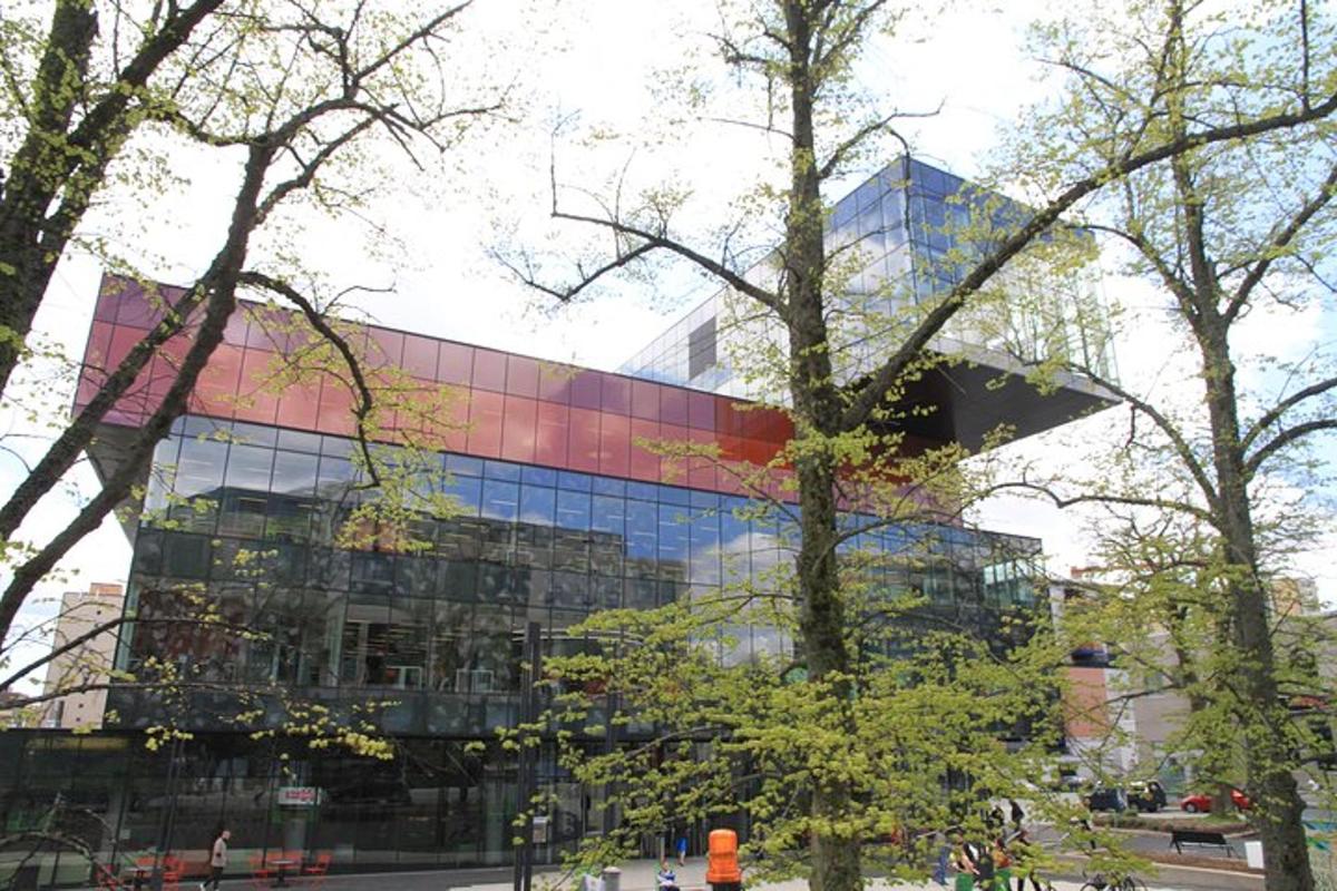 a large glass building with trees in front of it