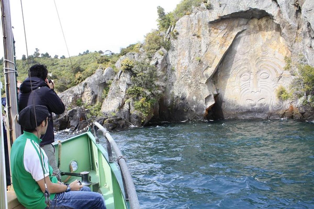 due persone su una barca di fronte a una formazione rocciosa