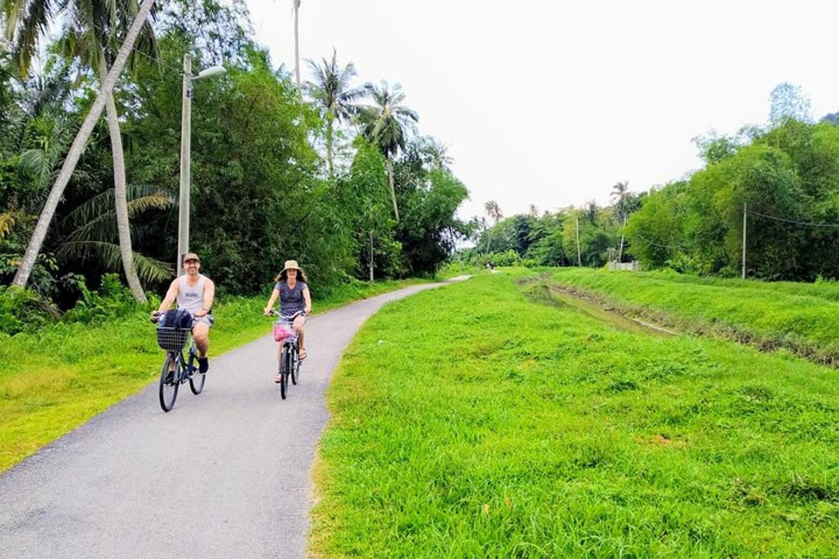 two people riding bikes down a dirt road