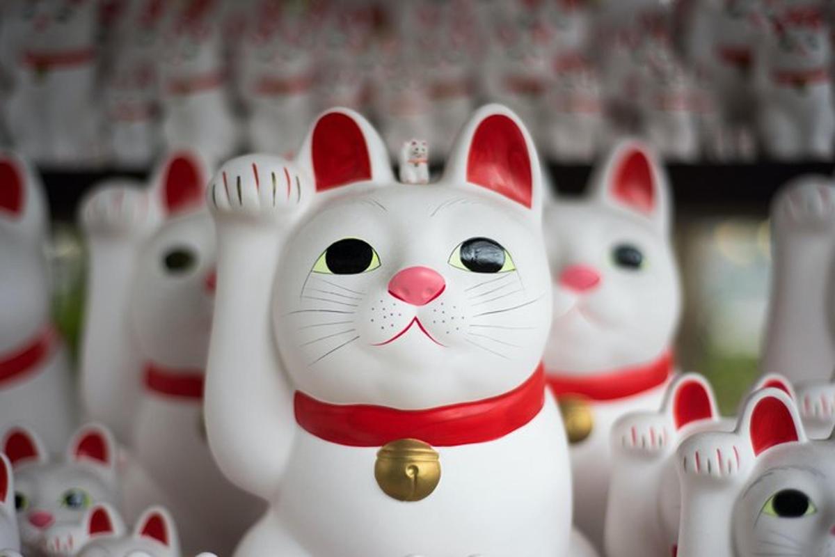 sekumpulan patung kucing putih berbaris