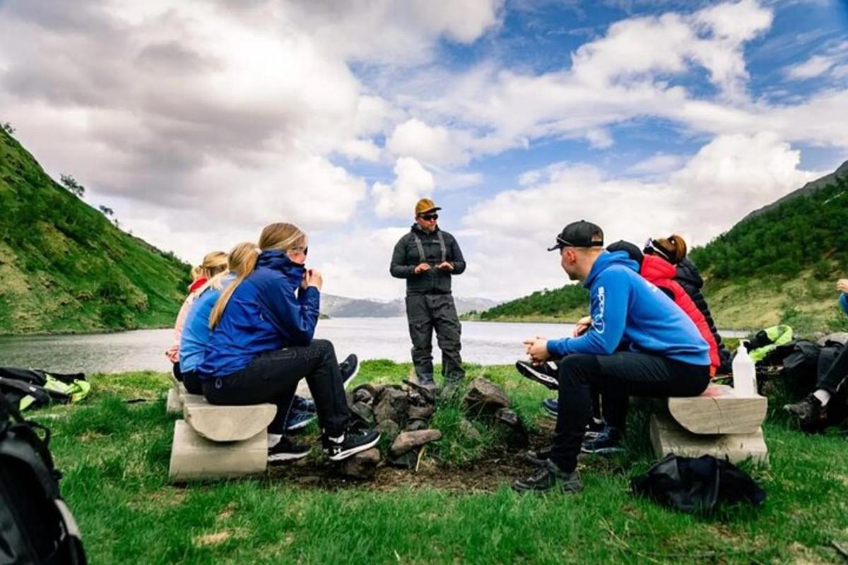 a group of people sitting on benches by a river