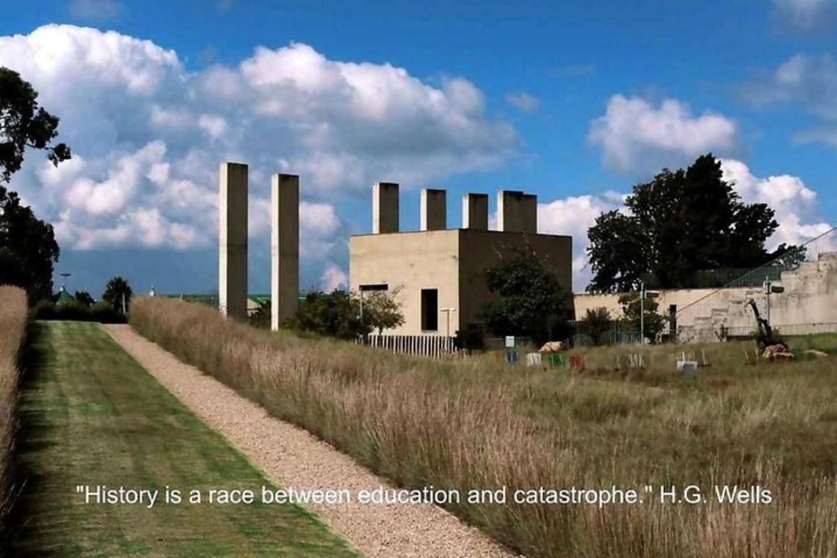 a building with smoke stacks next to a field