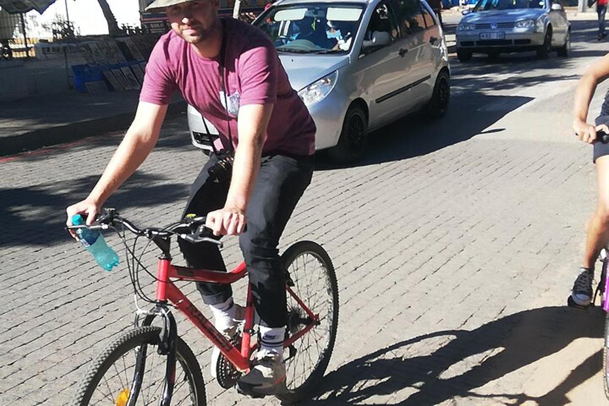 muž jedoucí po ulici na červeném kole