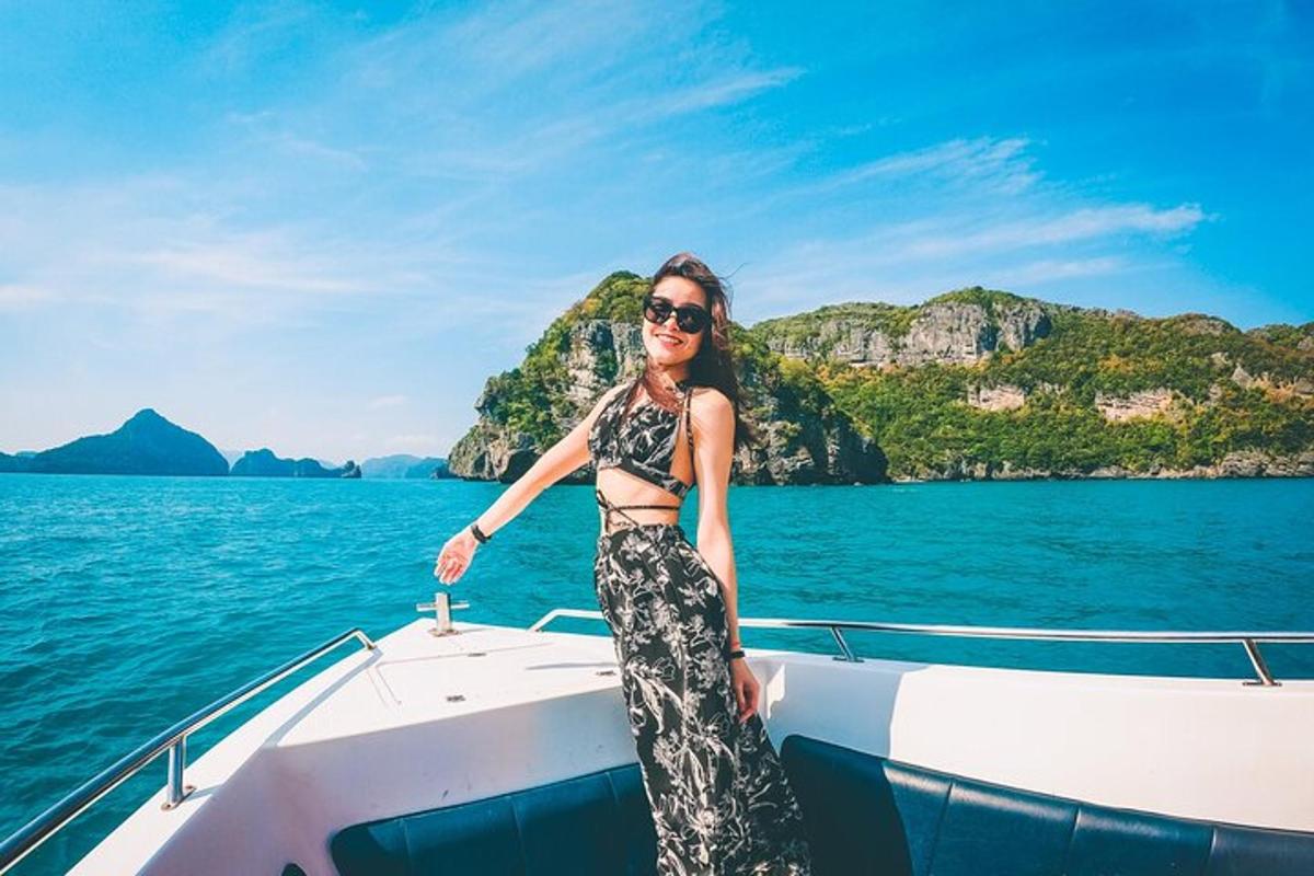 Una mujer parada en la parte delantera de un barco en el agua.