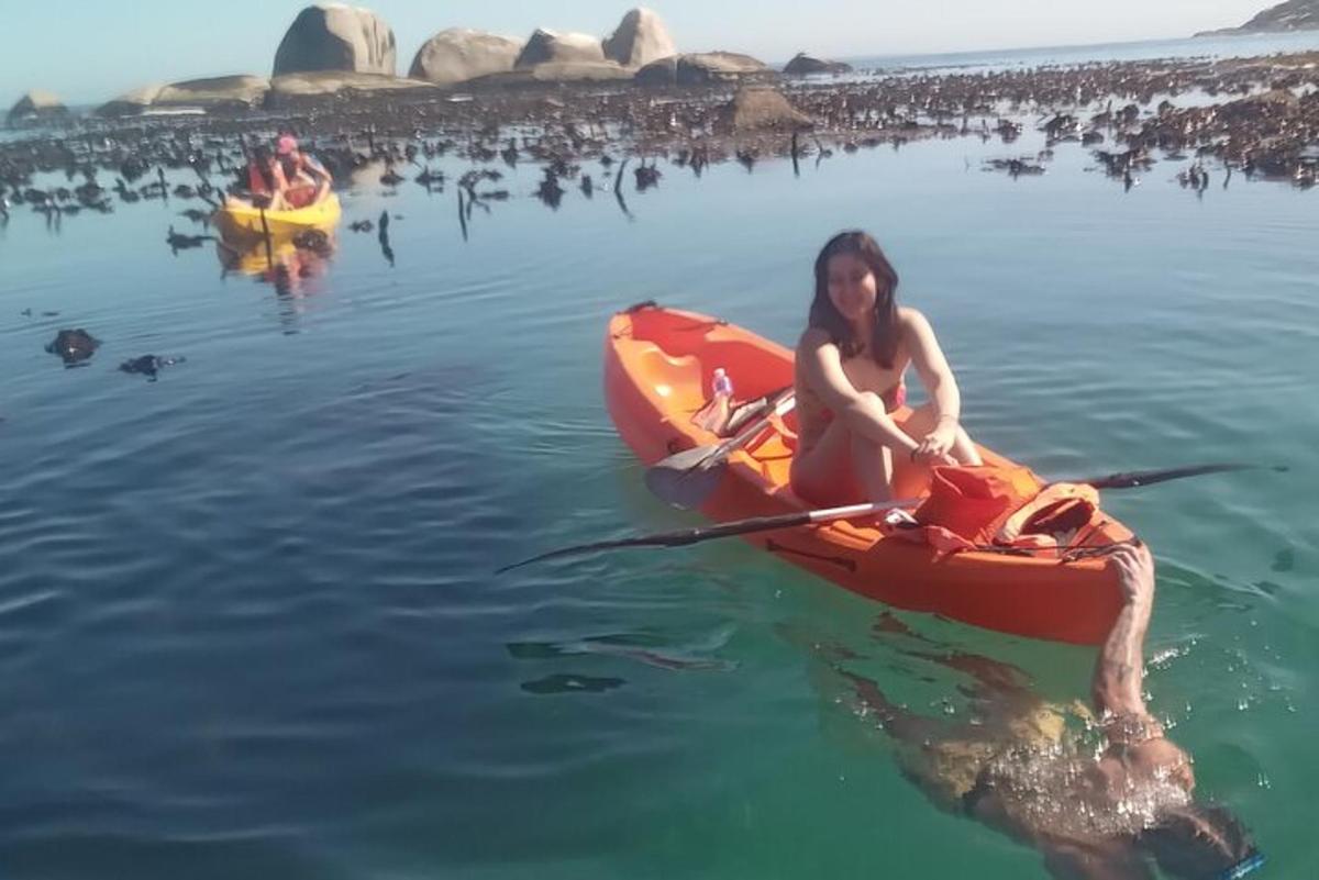 una dona en un caiac a l'aigua amb una tortuga