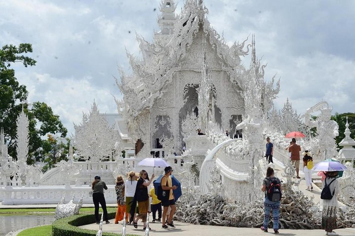 a group of people standing in front of a white temple