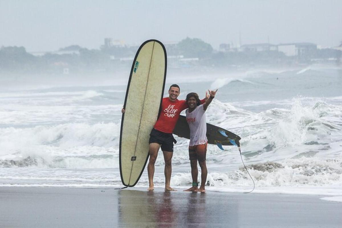 a man and woman standing on the beach with a surfboard