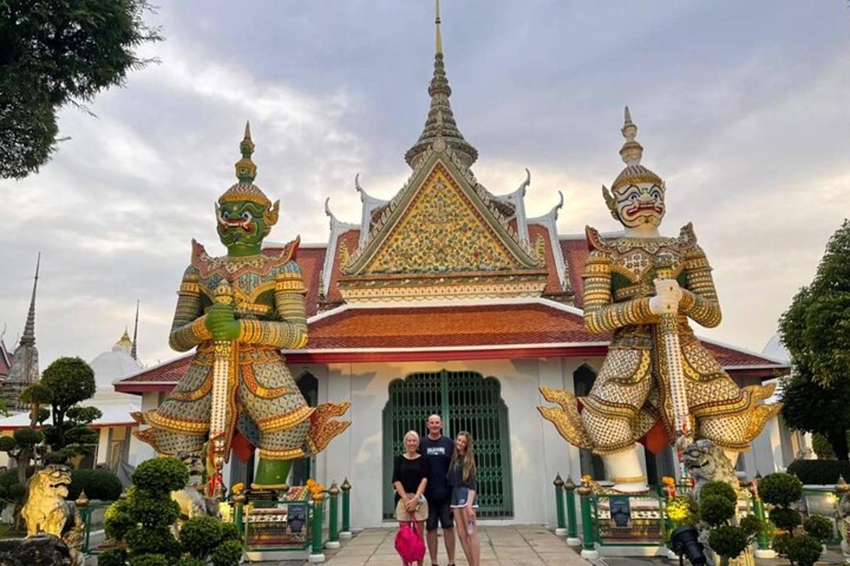 a group of people standing in front of a building with two large statues