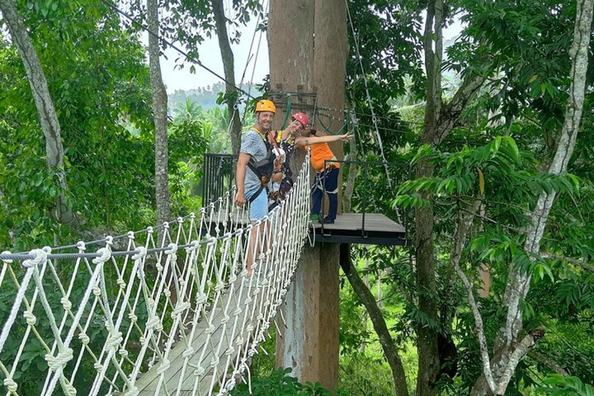 Dos personas en un puente colgante en el bosque.